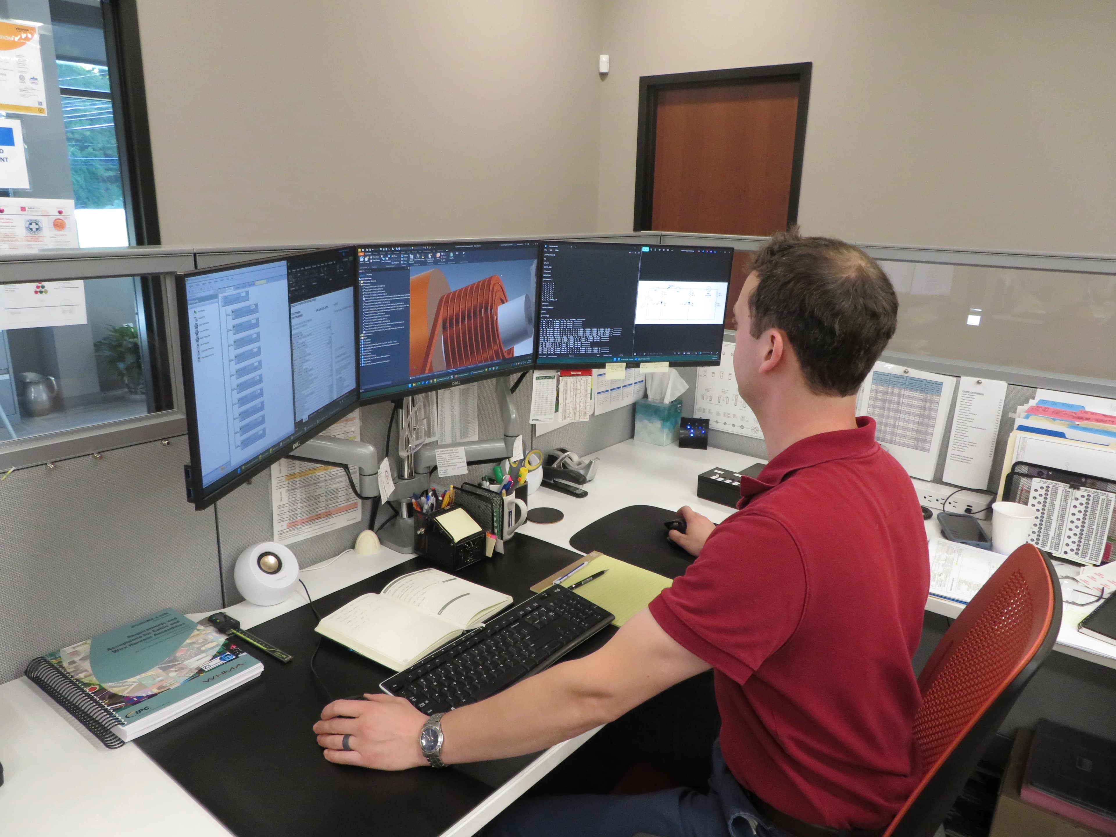 Engineer at computer workstation with product design on screen