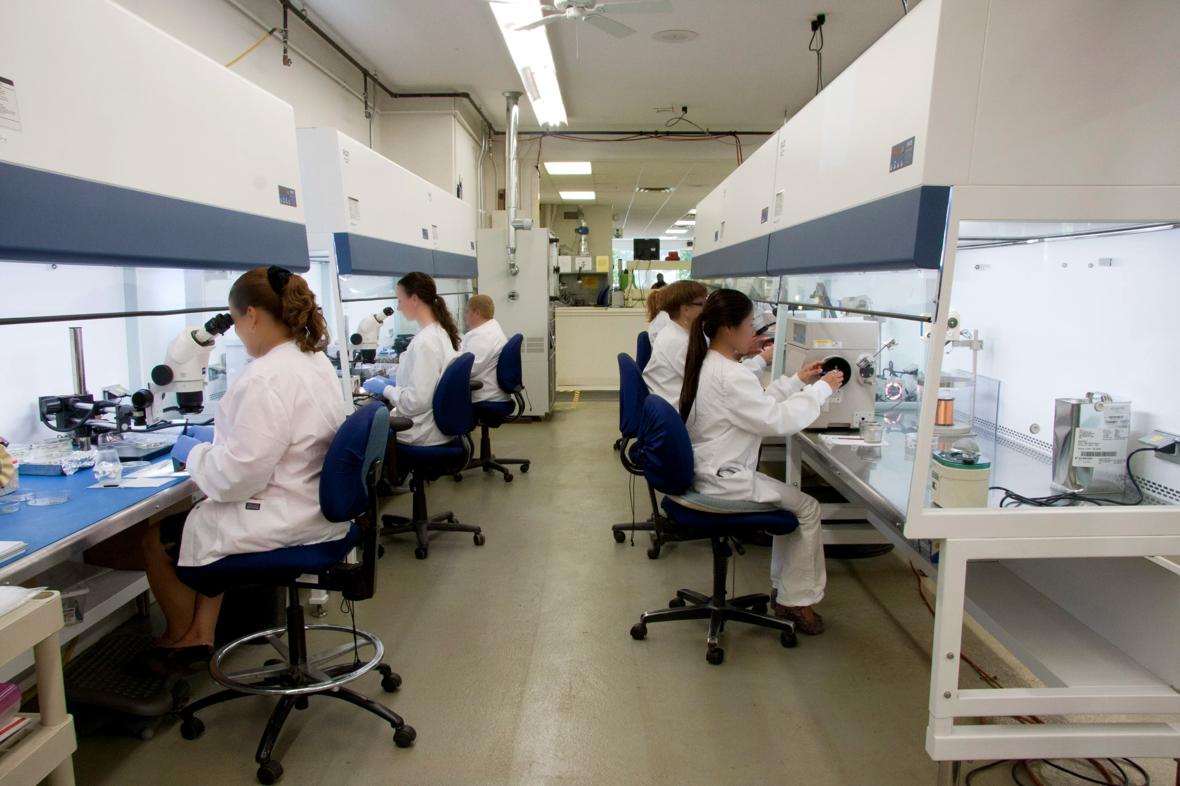 Multiple workers manufacturing electromagnetic parts at various stations